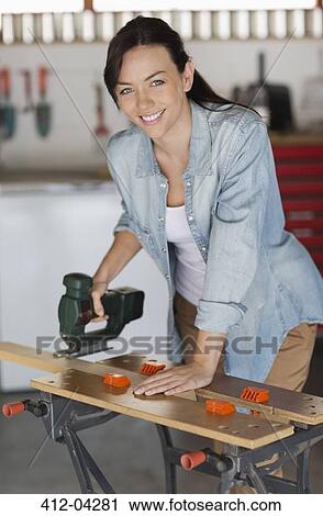 Stock Image - Woman working in workshop. Fotosearch