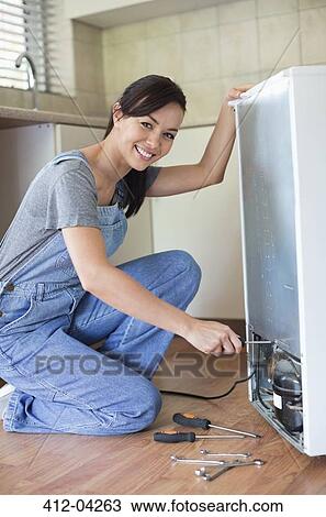 Woman working on appliance in kitchen View Large Photo Image Stock Image - Woman working on appliance in kitchen. Fotosearch
