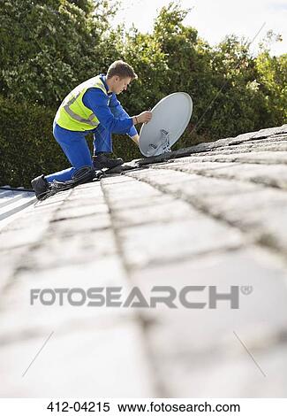 Worker installing satellite dish on roof View Large Photo Image Stock Photography - Worker installing satellite dish on roof. Fotosearch