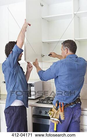 Workers installing cabinets in kitchen View Large Photo Image Stock Image - Workers installing cabinets in kitchen. Fotosearch