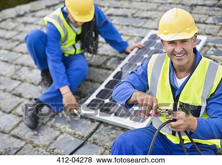 Workers installing solar panel on roof View Large Photo Image Stock Photo - Workers installing solar panel on roof. Fotosearch