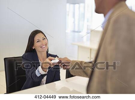Business people exchanging cards in office View Large Photo Image Stock Photo - Business people exchanging cards in office. Fotosearch