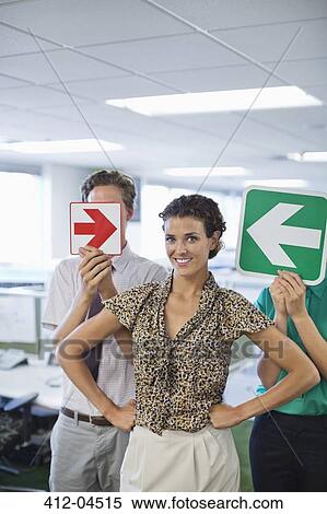 Business people holding arrows in office View Large Photo Image Stock Photography - Business people holding arrows in office. Fotosearch