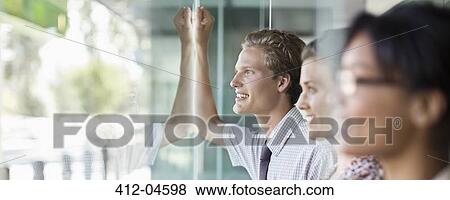 Business people looking out office window View Large Photo Image Stock Photo - Business people looking out office window. Fotosearch