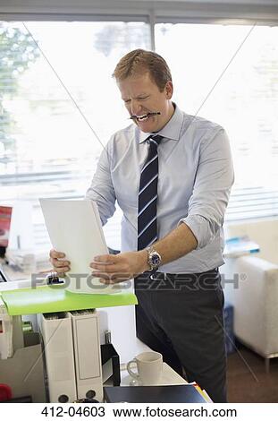 Stock Image - Businessman holding folders in office. Fotosearch