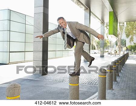 Stock Image - Businessman playing on city street. Fotosearch
