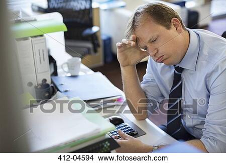 Businessman sighing at desk View Large Photo Image Picture - Businessman sighing at desk. Fotosearch