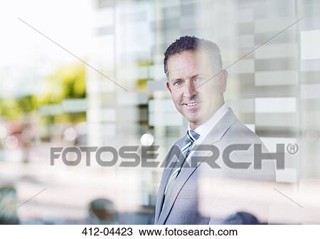 Businessman smiling in office View Large Photo Image Stock Image - Businessman smiling in office. Fotosearch
