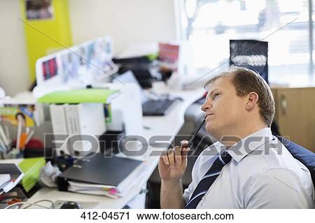 Stock Image - Businessman thinking at desk. Fotosearch
