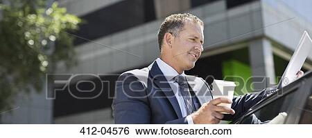 Businessman using tablet computer outdoors View Large Photo Image Stock Photograph - Businessman using tablet computer outdoors. Fotosearch