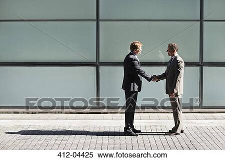 Stock Photography - Businessmen shaking hands outdoors. Fotosearch