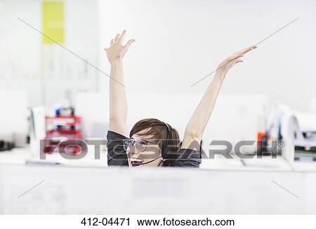 Businesswoman in headset cheering at desk View Large Photo Image Stock Image - Businesswoman in headset cheering at desk. Fotosearch