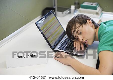 Stock Image - Businesswoman sleeping on? out of order? lapto. Fotosearch