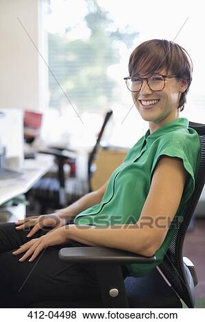 Businesswoman smiling at desk View Large Photo Image Stock Photo - Businesswoman smiling at desk. Fotosearch