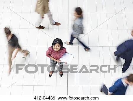Businesswoman smiling in busy office hallway View Large Photo Image Stock Photography - Businesswoman smiling in busy office hallway. Fotosearch