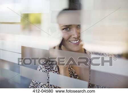 Stock Image - Businesswoman talking on cell phone. Fotosearch