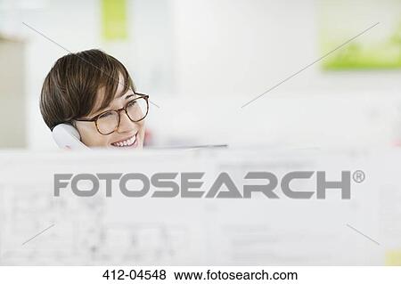Businesswoman talking on phone at desk View Large Photo Image Stock Photo - Businesswoman talking on phone at desk. Fotosearch