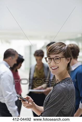 Businesswoman using cell phone in meeting View Large Photo Image Stock Image - Businesswoman using cell phone in meeting. Fotosearch