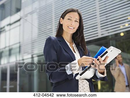 Stock Image - Businesswoman walking on city street. Fotosearch