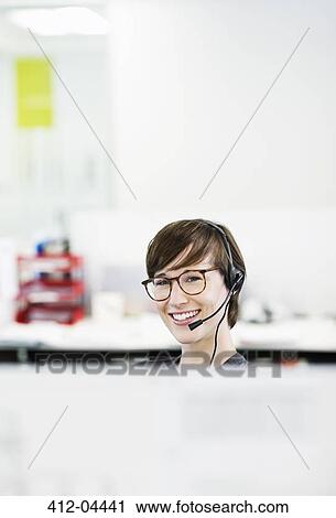 Businesswoman wearing headset in office View Large Photo Image Stock Image - Businesswoman wearing headset in office. Fotosearch