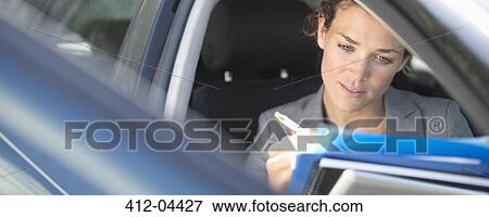 Businesswoman working in car View Large Photo Image Stock Photo - Businesswoman working in car. Fotosearch