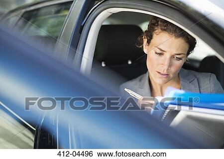 Businesswoman working in car View Large Photo Image Stock Photograph - Businesswoman working in car. Fotosearch