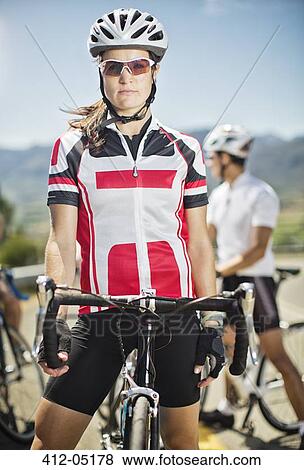 Stock Photo - Cyclist standing by bicycle before race. Fotosearch