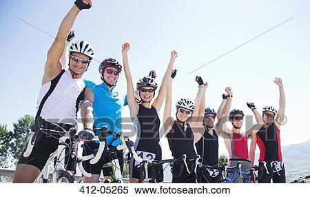 Stock Photography - Cyclists cheering together outdoors. Fotosearch