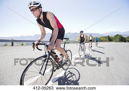 Stock Image - Cyclists in race on rural road. Fotosearch