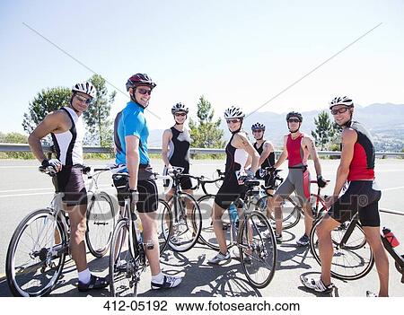 Stock Image - Cyclists smiling together on rural road. Fotosearch