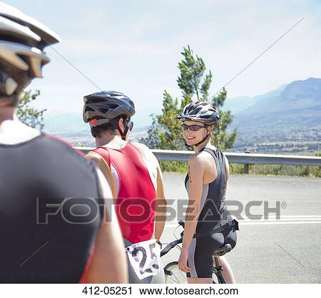 Stock Image - Cyclists talking on rural road. Fotosearch