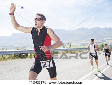 Runner spraying himself with water in race View Large Photo Image Stock Photograph - Runner spraying himself with water in race. Fotosearch