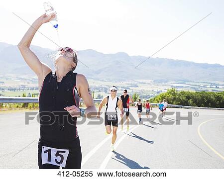 Stock Photography - Runner spraying water on rural road. Fotosearch