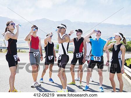 Runners drinking water on rural road View Large Photo Image Stock Photo - Runners drinking water on rural road. Fotosearch