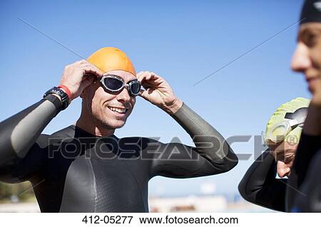 Triathlete adjusting goggles outdoors View Large Photo Image Stock Photo - Triathlete adjusting goggles outdoors. Fotosearch