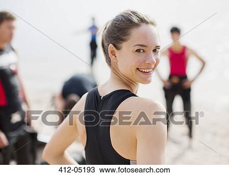 Stock Image - Triathlete smiling on beach. Fotosearch