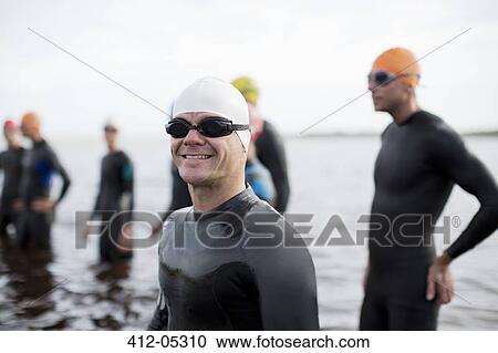 Stock Image - Triathlete smiling on beach. Fotosearch