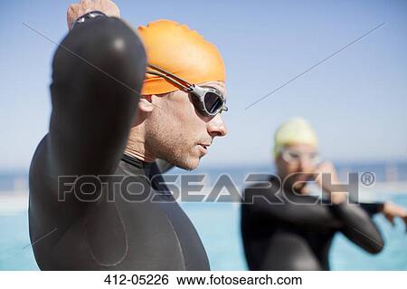 Triathlete tying on goggles outdoors View Large Photo Image Stock Photograph - Triathlete tying on goggles outdoors. Fotosearch