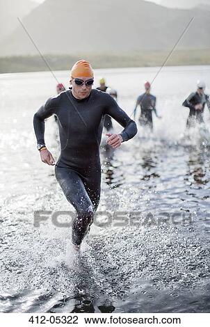 Triathletes emerging from water View Large Photo Image Stock Image - Triathletes emerging from water. Fotosearch