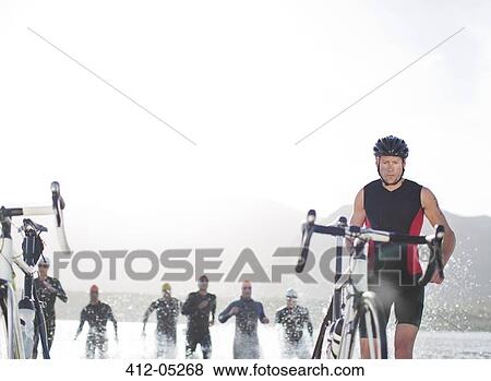 Triathletes emerging from water, View Large Photo Image Stock Photo - Triathletes emerging from water, . Fotosearch