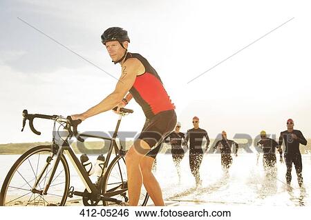 Triathletes emerging from water View Large Photo Image Stock Photograph - Triathletes emerging from water. Fotosearch