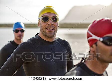 Triathletes in wetsuit smiling in water View Large Photo Image Stock Photo - Triathletes in wetsuit smiling in water. Fotosearch