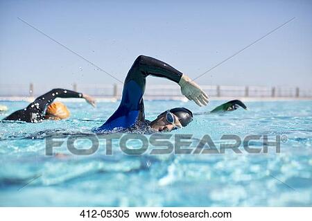 Triathletes in wetsuits racing in pool View Large Photo Image Stock Photography - Triathletes in wetsuits racing in pool. Fotosearch