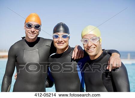 Triathletes in wetsuits smiling together View Large Photo Image Picture - Triathletes in wetsuits smiling together. Fotosearch