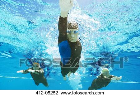 Stock Image - Triathletes in wetsuits underwater. Fotosearch
