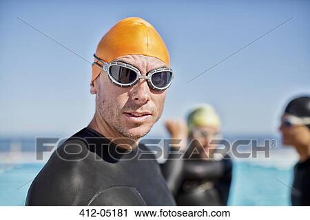 Triathletes in wetsuits wearing goggles and cap View Large Photo Image Stock Image - Triathletes in wetsuits wearing goggles and cap. Fotosearch