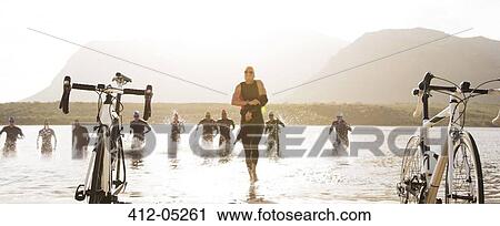 Triathletes running to bicycles on beach View Large Photo Image Stock Image - Triathletes running to bicycles on beach. Fotosearch