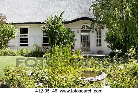 Stock Photograph - Birdbath in garden outside house. Fotosearch