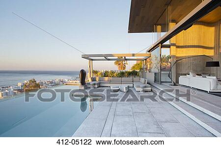 Stock Image - Infinity pool and patio of modern house. Fotosearch