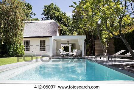 Lawn chairs and swimming pool in backyard View Large Photo Image Stock Photo - Lawn chairs and swimming pool in backyard. Fotosearch